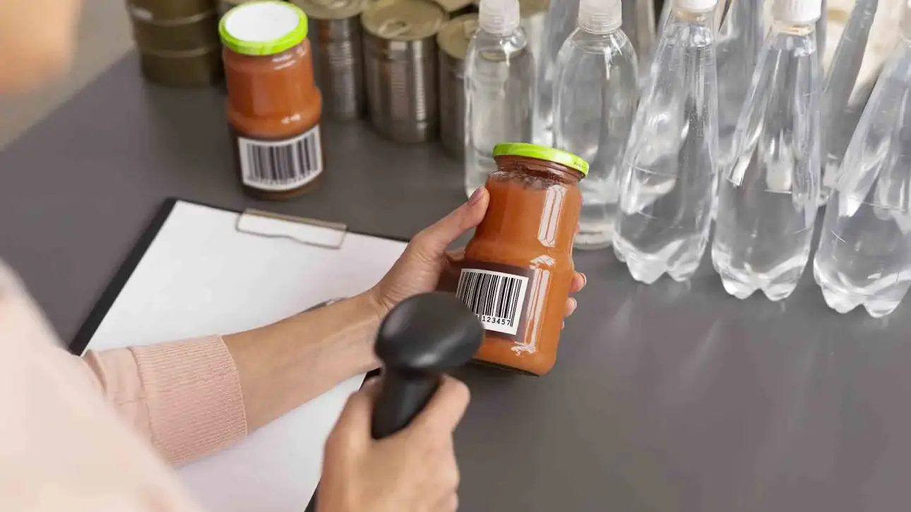 Trabajador escaneando envases alimentarios con código de barras para control de trazabilidad.