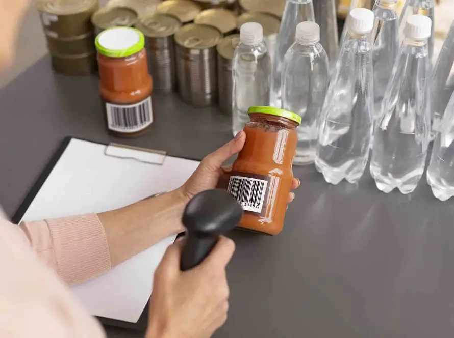 Trabajador escaneando envases alimentarios con código de barras para control de trazabilidad.