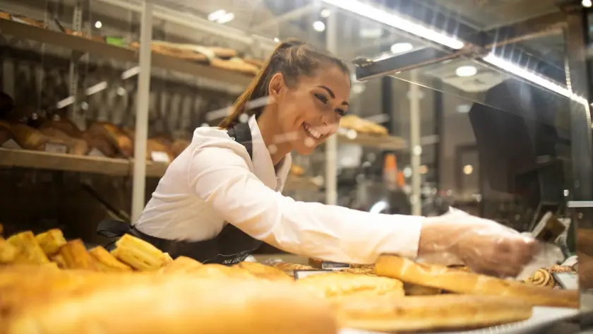 Trabajadora de panadería cumpliendo prerrequisitos en la industria alimentaria